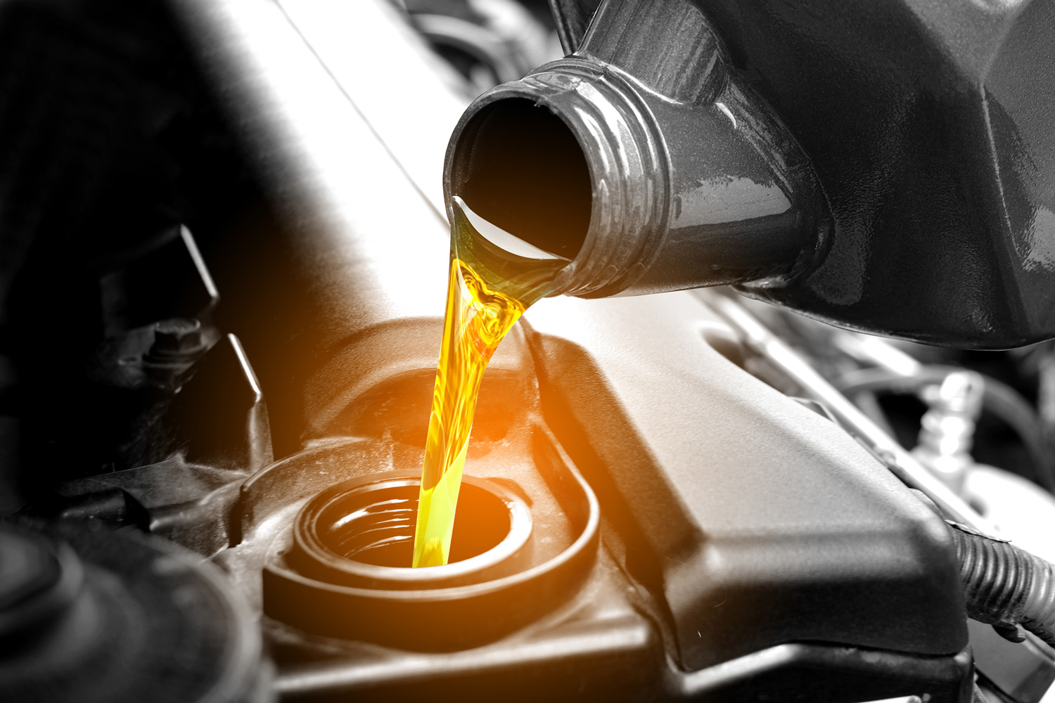 Closeup od car engine oil being poured into the engine as part of car servicing